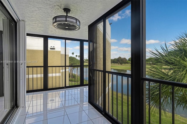 unfurnished sunroom featuring a water view