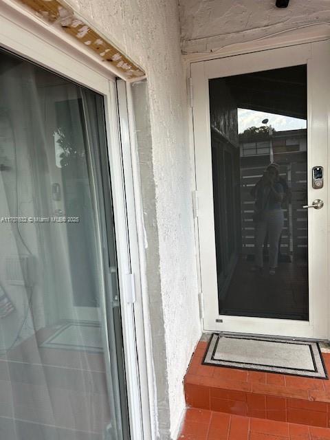 entrance to property featuring stucco siding