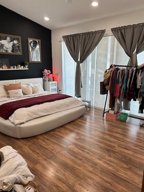 bedroom with lofted ceiling, wood finished floors, and recessed lighting