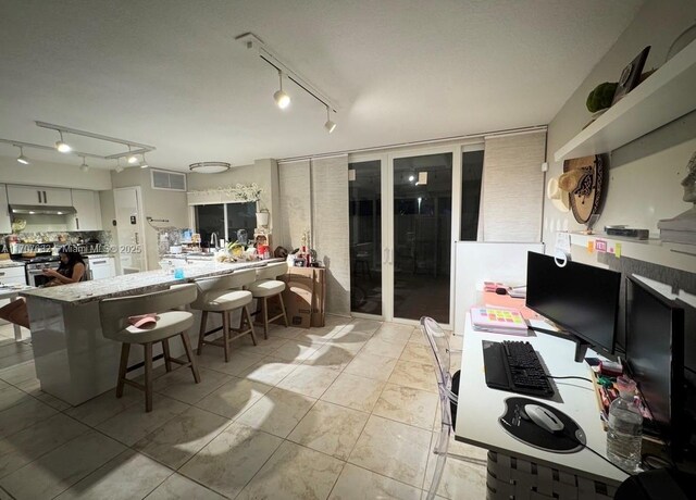 kitchen featuring visible vents, stainless steel gas stove, white cabinetry, a peninsula, and a kitchen breakfast bar