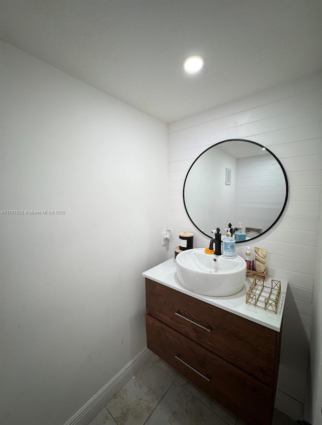 bathroom featuring marble finish floor, vanity, and baseboards