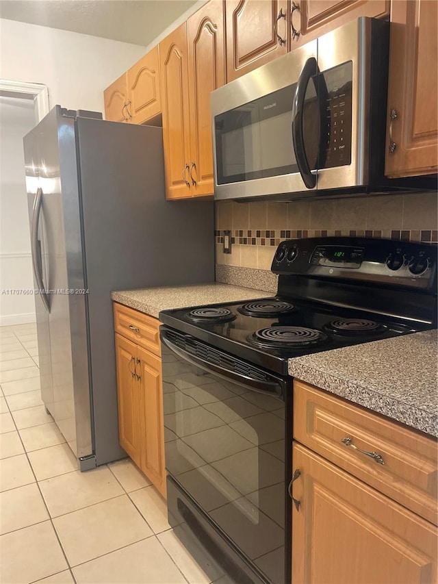 kitchen featuring backsplash, light tile patterned floors, and appliances with stainless steel finishes