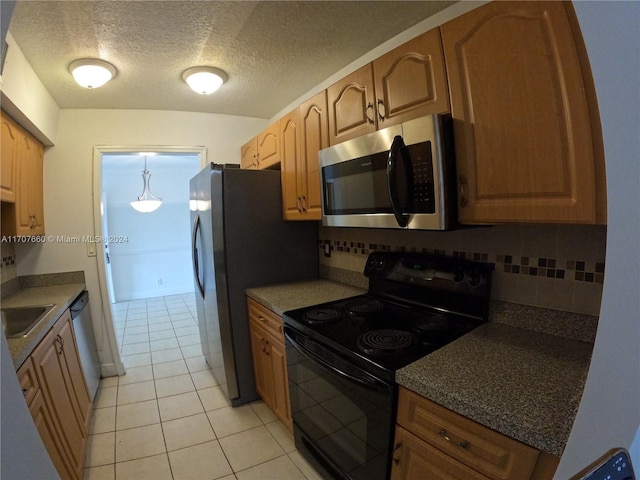 kitchen with backsplash, sink, light tile patterned floors, a textured ceiling, and appliances with stainless steel finishes