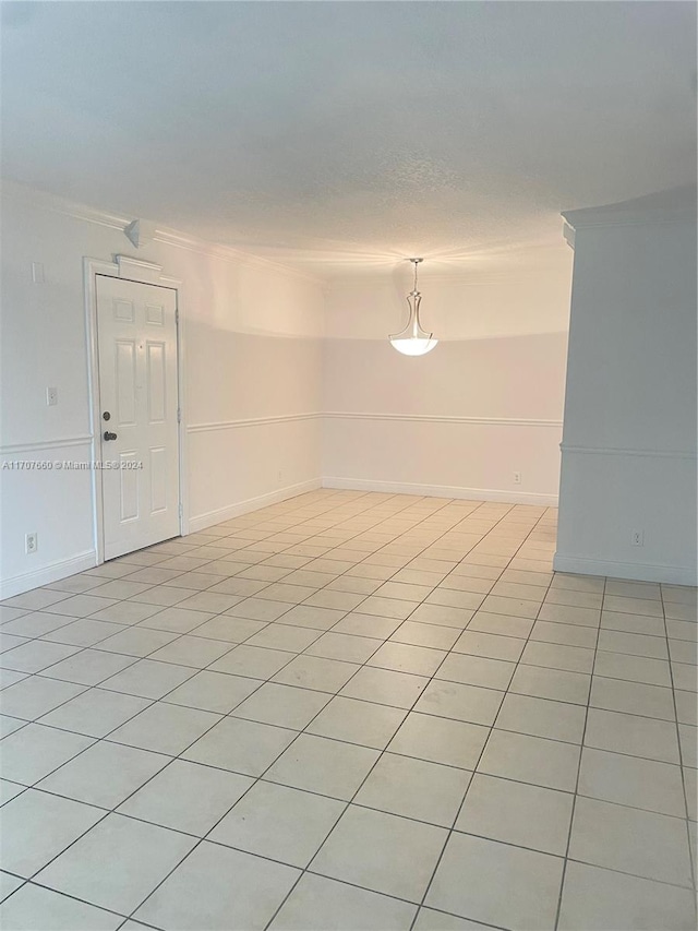 tiled spare room with crown molding