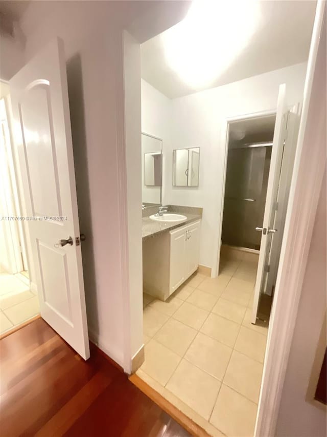 bathroom featuring a shower with door, vanity, and hardwood / wood-style flooring