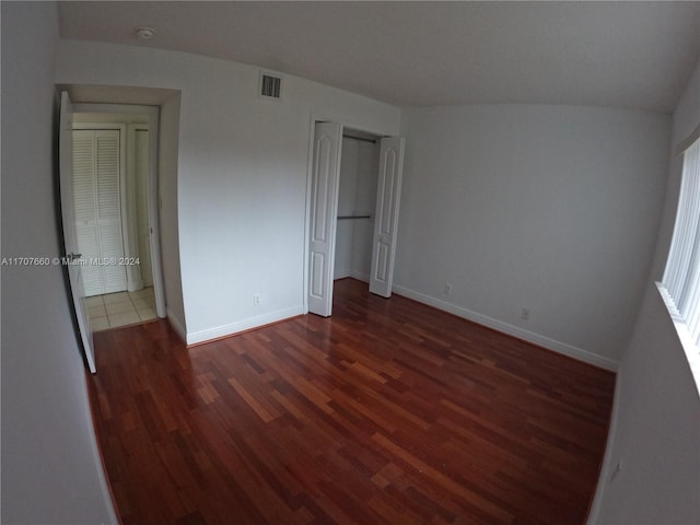 unfurnished bedroom with dark hardwood / wood-style flooring