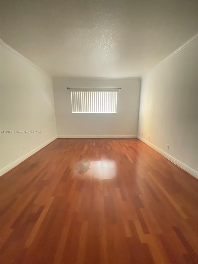 empty room featuring hardwood / wood-style floors and ornamental molding