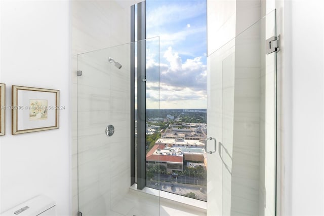 bathroom featuring tile patterned flooring, toilet, and a shower with door