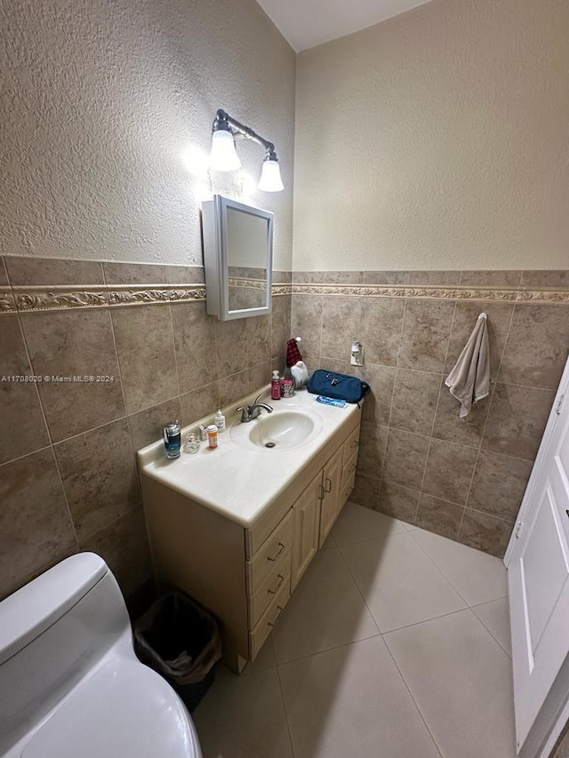 bathroom with tile patterned floors, vanity, tile walls, and toilet