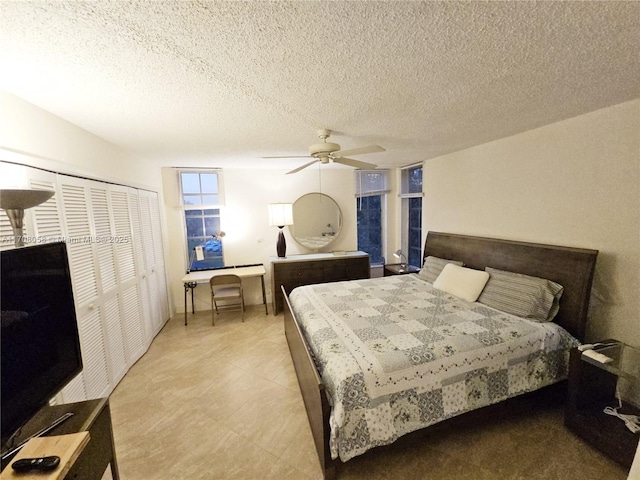 bedroom with a textured ceiling, ceiling fan, and a closet