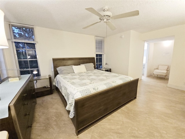 bedroom with ceiling fan and a textured ceiling