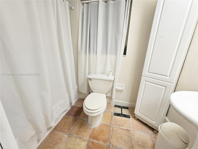 bathroom featuring a shower with curtain and toilet