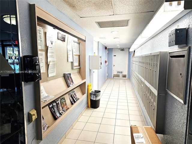 corridor featuring light tile patterned floors and a mail area