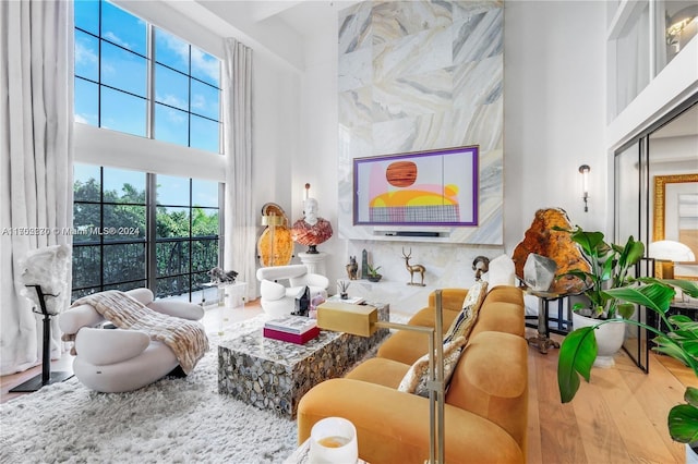 living room with hardwood / wood-style floors, a towering ceiling, and tile walls