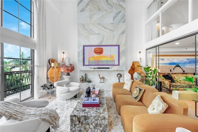 living room with a wealth of natural light, a towering ceiling, and tile walls