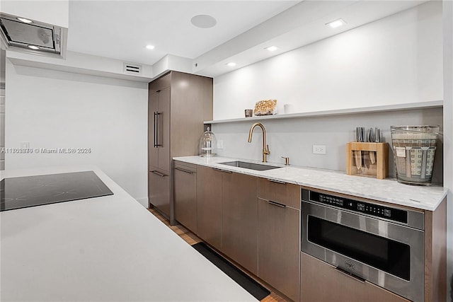 101 N Clematis St Unit 308, West Palm Beach, FL 33401 - kitchen with stainless steel microwave, open shelves, black electric cooktop, light countertops, and recessed lighting