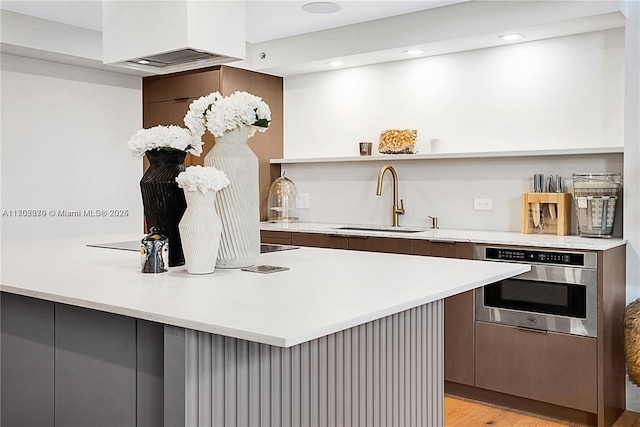 101 N Clematis St Unit 308, West Palm Beach, FL 33401 - kitchen featuring modern cabinets, light countertops, open shelves, light wood-style floors, and stainless steel oven