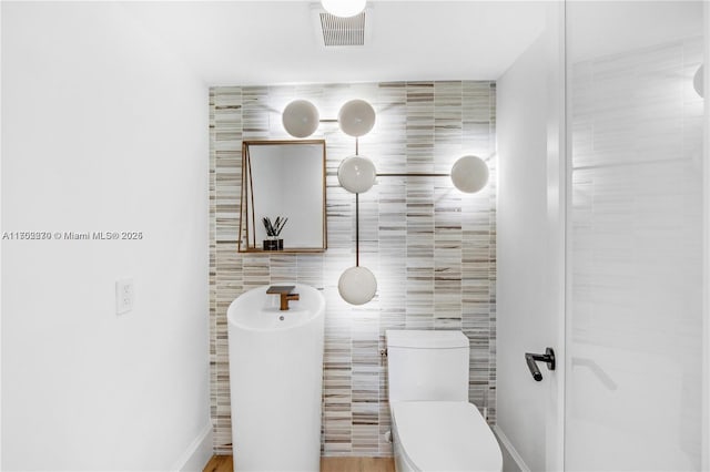 101 N Clematis St Unit 308, West Palm Beach, FL 33401 - bathroom featuring toilet and tile walls