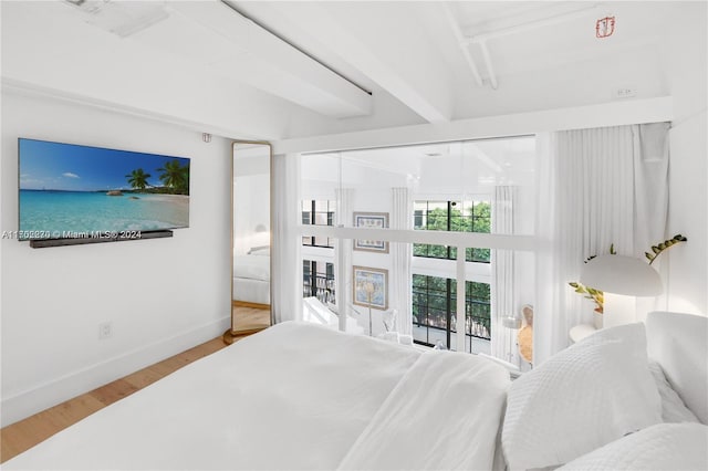 bedroom featuring beam ceiling, access to exterior, and hardwood / wood-style flooring