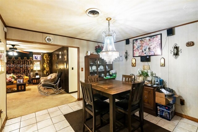carpeted dining area featuring crown molding and ceiling fan with notable chandelier