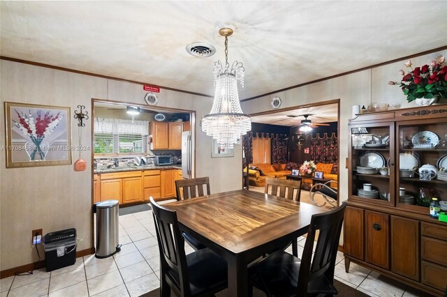 tiled dining room with ceiling fan with notable chandelier and ornamental molding