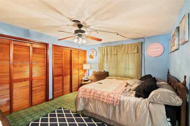carpeted bedroom featuring multiple closets and ceiling fan