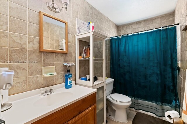 bathroom with walk in shower, vanity, tile walls, and toilet