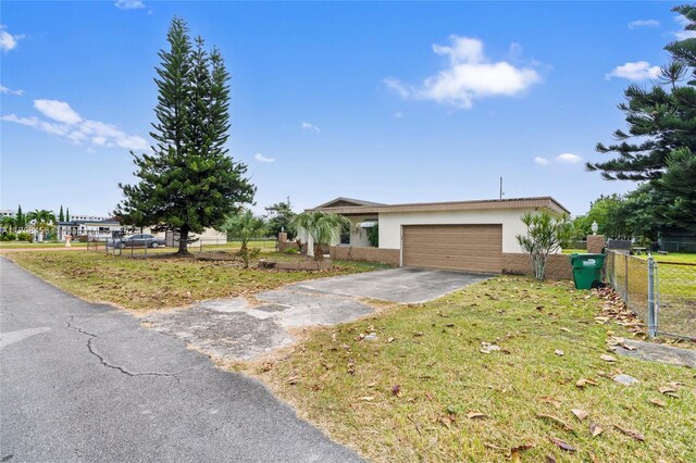 single story home featuring a garage and a front yard