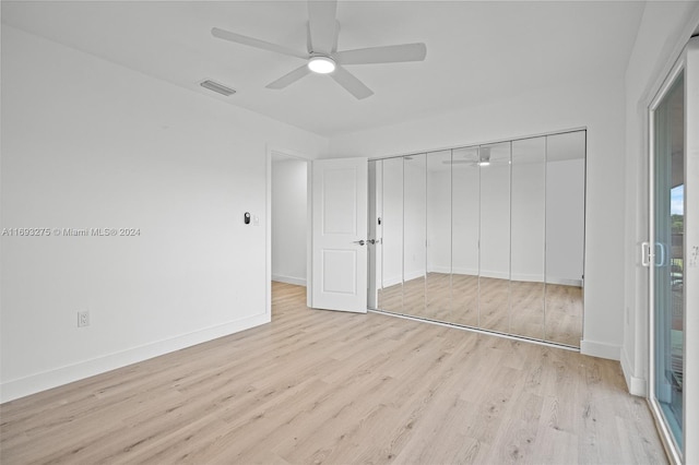 unfurnished bedroom featuring ceiling fan, a closet, and light wood-type flooring