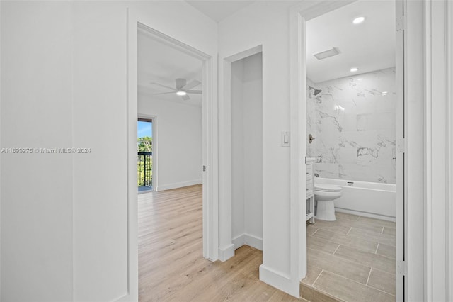 bathroom with hardwood / wood-style floors, tiled shower / bath combo, toilet, and ceiling fan