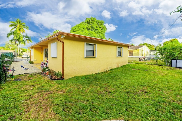 view of home's exterior with stucco siding, a yard, and a fenced backyard