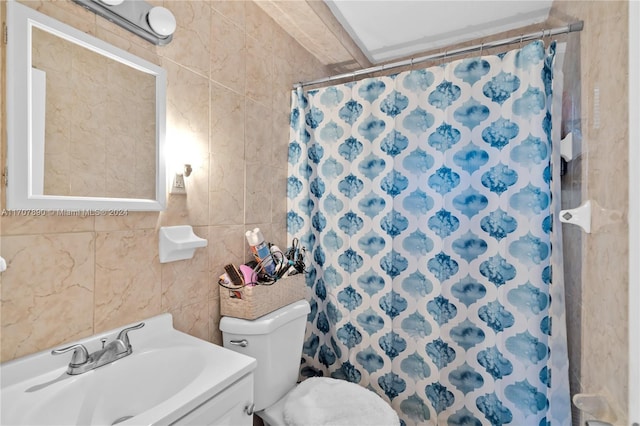 bathroom featuring walk in shower, vanity, toilet, and tile walls