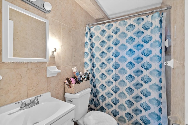 full bathroom with tile walls, curtained shower, toilet, and a sink