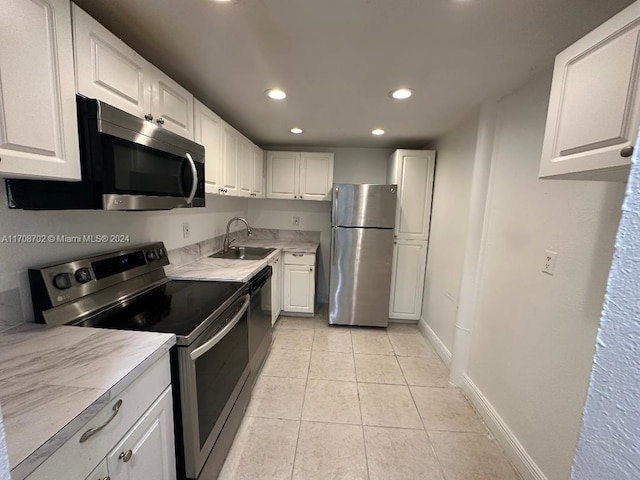 kitchen featuring white cabinets, light tile patterned floors, sink, and appliances with stainless steel finishes