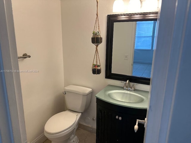 bathroom with tile patterned flooring, vanity, and toilet