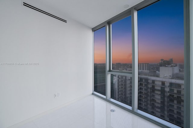 tiled spare room with a wall of windows