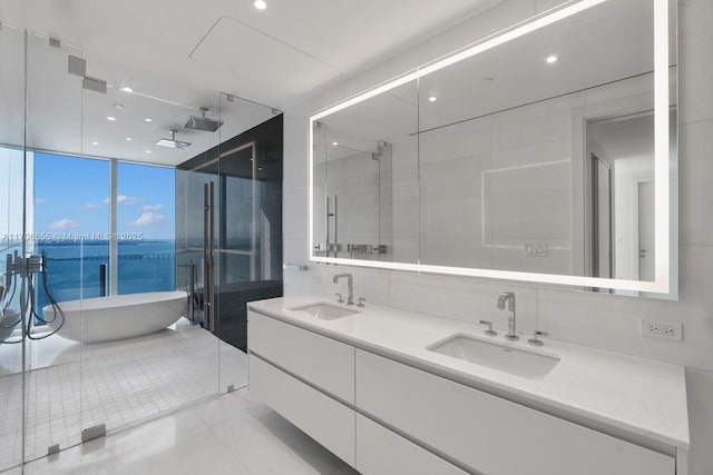 bathroom with tile patterned flooring, floor to ceiling windows, a water view, vanity, and shower with separate bathtub