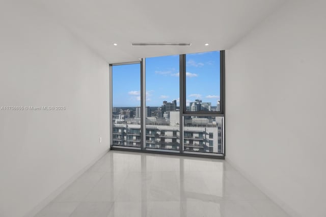 spare room featuring expansive windows and tile patterned floors