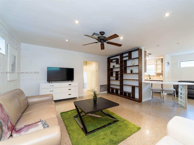 living room featuring ceiling fan and sink