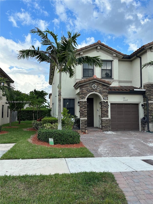 view of front of property featuring a front yard and a garage