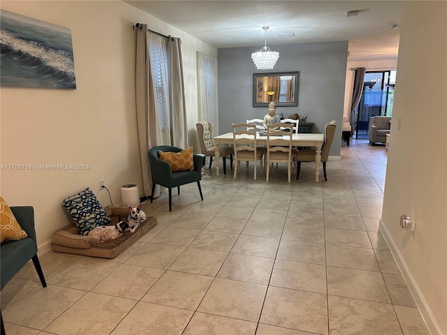 dining space featuring light tile patterned flooring and a chandelier