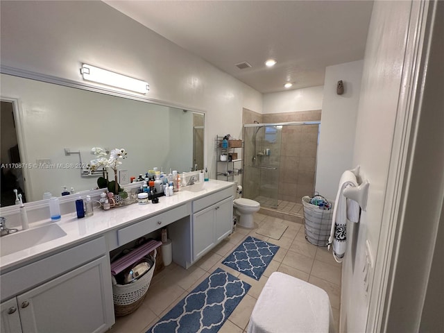 bathroom with tile patterned floors, vanity, a shower with shower door, and toilet