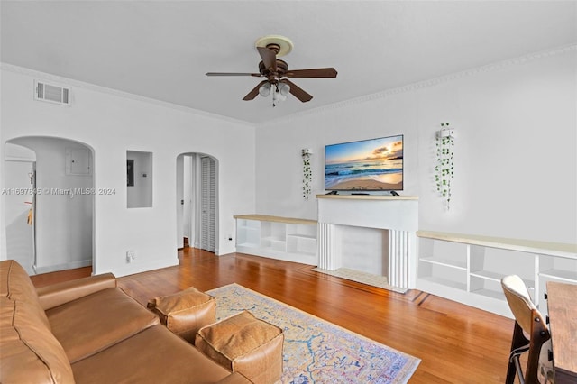 living room with ceiling fan, crown molding, and wood-type flooring