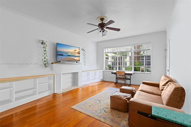 living room with hardwood / wood-style floors, ceiling fan, and crown molding