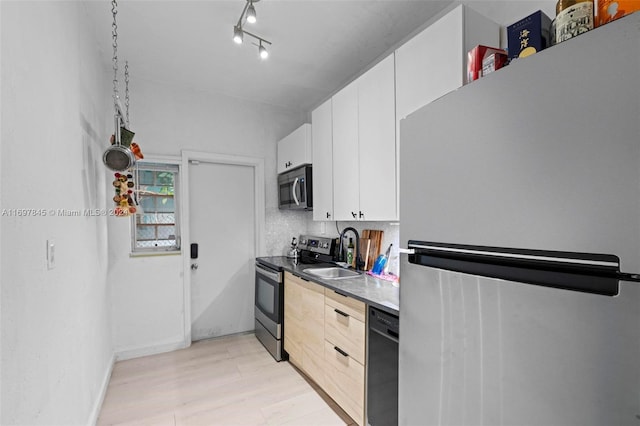 1571 Pennsylvania Ave Unit 4S, Miami Beach, FL 33139 - kitchen featuring stainless steel appliances, light wood-style floors, white cabinetry, and decorative backsplash