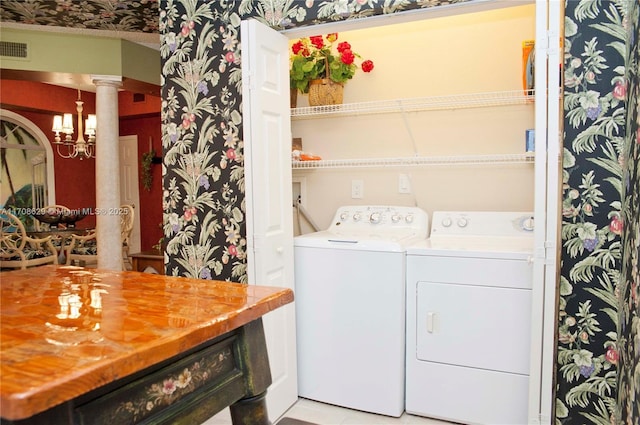 laundry room with ornate columns and washing machine and clothes dryer