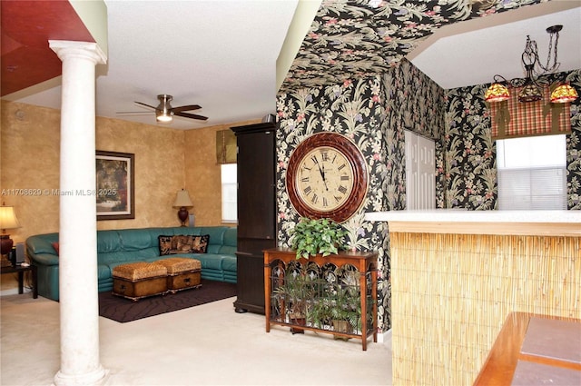 living room featuring carpet flooring, ceiling fan, and ornate columns