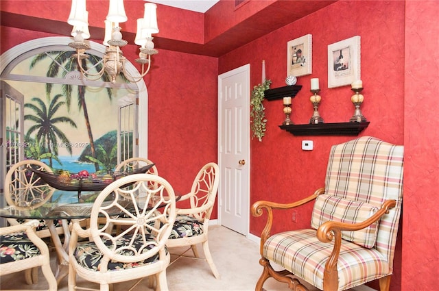 sitting room with an inviting chandelier and carpet floors