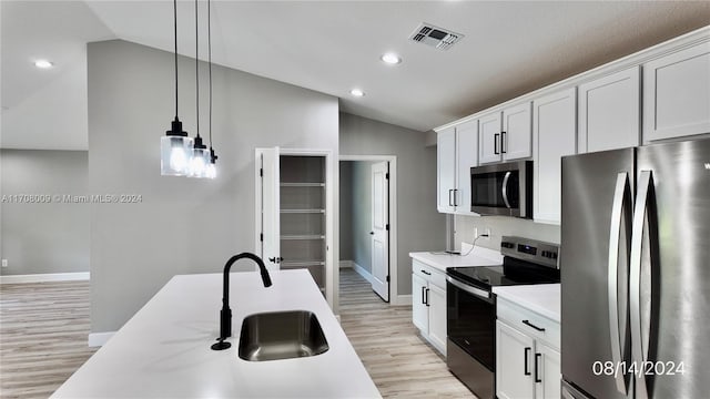 kitchen featuring sink, white cabinets, stainless steel appliances, and vaulted ceiling