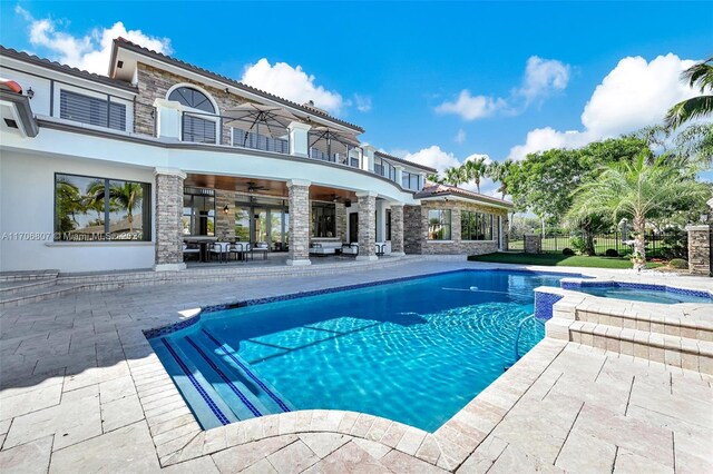 view of pool with ceiling fan, a patio area, and an in ground hot tub